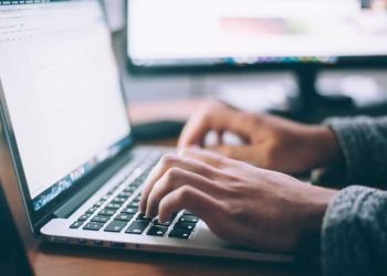 Mand skriver på laptop